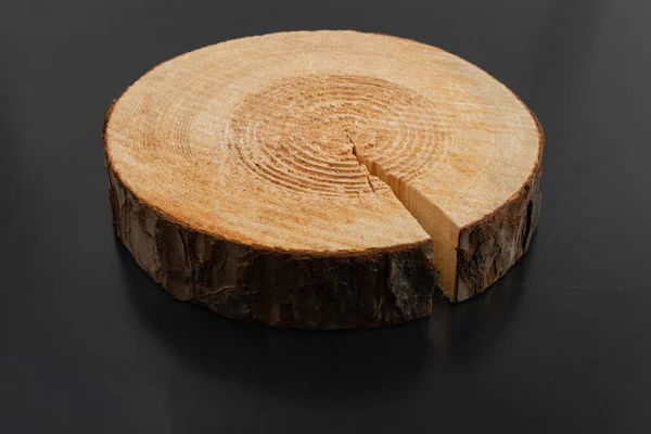 Wooden stump, cross section, cut wood tree trunk slice, circular piece of pine on black background