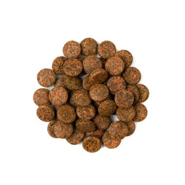 Bastırılmış kahverengi haplar izole edilmiş. Bitki tabletleri, besin takviyeleri, akvaryum karideslerini beslemek için tabletler, turba topakları, beyaz arka planda sıkıştırılmış gübre.