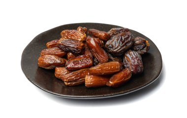 Siyah tabakta büyük tarihler izole edilmiş. Kuru hurma meyveleri, jöle, medjul veya majhool, beyaz arka planda kraliyet tarihleri