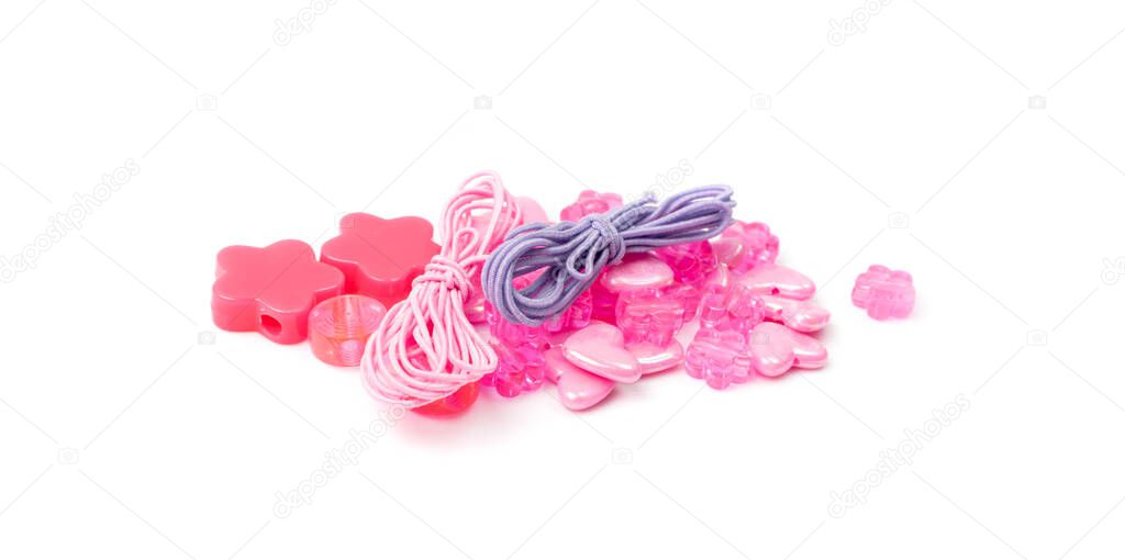 Pink bead hearts and flowers isolated. Beading craft accessory, flower beads pile, beadwork handicraft elements on white background top view