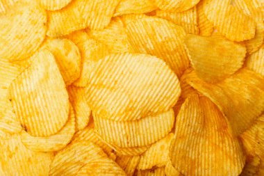 Patates cipsi dokusu arka planı. Çıtır çıtır patates çerez kalıbı, fast food aperatifleri duvar kağıdı üst görünümü.
