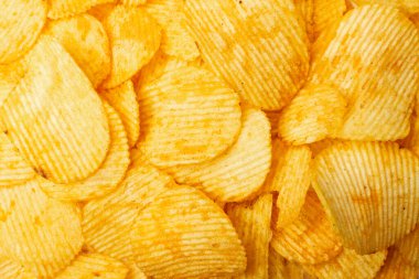 Patates cipsi dokusu arka planı. Çıtır çıtır patates çerez kalıbı, fast food aperatifleri duvar kağıdı üst görünümü.