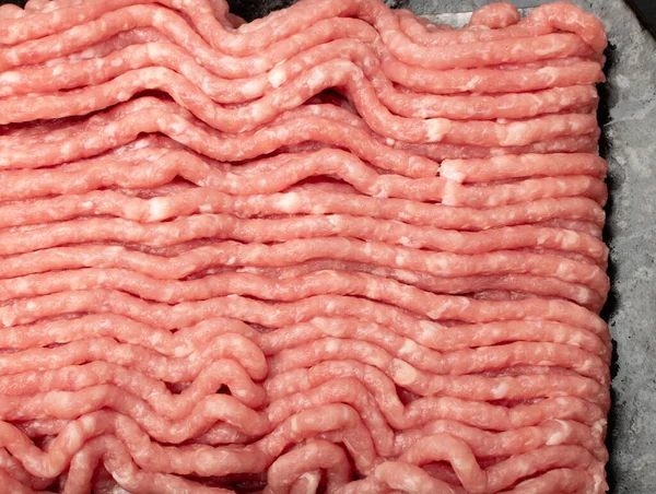 Pork mince meat texture background. Ground fresh pig fillet textured pattern, uncooked pork mincemeat, raw forcemeat, farce meat top view