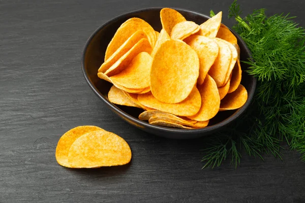 Potatischips Stapel Svart Skål Mörk Sten Bakgrund Närbild Knaprig Smal — Stockfoto