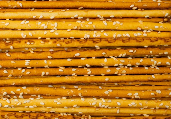 Bread sticks texture background. Pretzel sticks pattern, straws, sesame grissini wallpaper, pretzels snack, breadstick with sesame seeds, long rusks with copy space