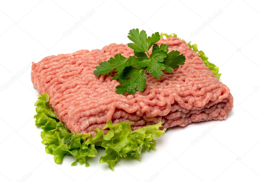 Turkey mince meat isolated. Ground fresh fillet, uncooked turkey mincemeat, raw forcemeat, farce meat portion with greens on white background