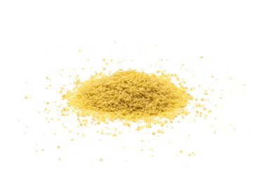 Kuskus yığını izole edilmiş. Kuru yastık, çiğ kuskus, pişmemiş kuskus veya beyaz arka planda irmik tanecikleri.