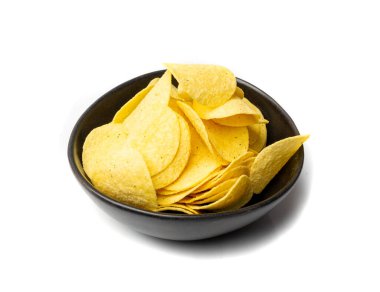 Potato chips pile in black bowl isolated. Crispy thin potato snack heap, fast food snacks with salt, spices powder on white background