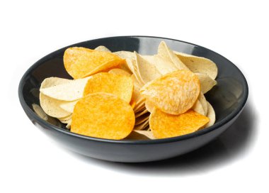 Potato chips pile in black bowl isolated. Crispy thin potato snack heap, fast food snacks with salt, spices powder on white background