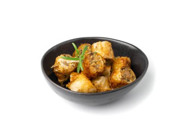 Spring rolls isolated. Rollos primavera pieces, fried rollito, arrollado, lumpia cuts, popiah, nem, sajgonki or fried dim sim pile in black bowl on white background
