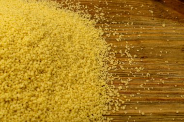 Kuskus dokusu arkaplan üstü görünümü. Kuru kümes deseni, çiğ kuskus duvar kâğıdı, pişmemiş öksürük ya da irmik tanecikleri, kopyalanmış ahşap kırsal arkaplan üzerine saçılmış.