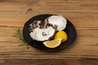 Ahşap masa arkasında boş istiridye kabuğu. Boş istiridye kabukları, yenmiş yumuşakçalar, kabuklu midyeler ya da ahşap kırsal masa üzerinde midyeler.