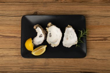 Ahşap masa arkasında boş istiridye kabuğu. Boş istiridye kabukları, yenmiş yumuşakçalar, kabuklu midyeler veya ahşap masa üstü manzaralı midyeler.