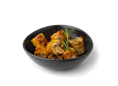 Spring rolls isolated. Rollos primavera pieces, fried rollito, arrollado, lumpia cuts, popiah, nem, sajgonki or fried dim sim pile in black bowl on white background