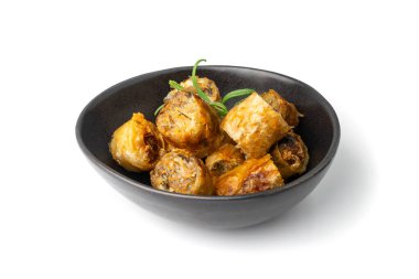 Spring rolls isolated. Rollos primavera pieces, fried rollito, arrollado, lumpia cuts, popiah, nem, sajgonki or fried dim sim pile in black bowl on white background