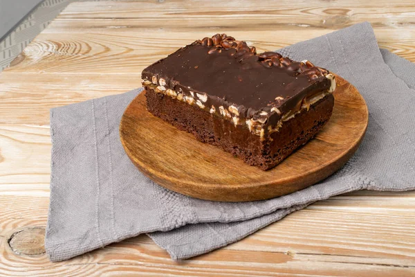 Homemade German chocolate cake. Nut brounie piece, square chocolate peanuts cake on wooden rustic background