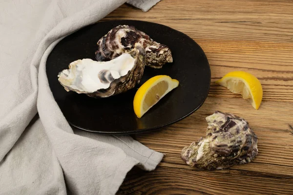 木製のテーブルの背景に空の牡蠣の殻 空の牡蠣の殻 木の素朴なテーブルデスクで軟体動物 貝や貝を食べた — ストック写真