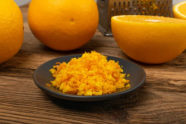 すりおろしたオレンジの皮の山 生の自家製柑橘系の皮 すりおろしたオレンジの皮 木の素朴な背景に新鮮なゼスト — ストック写真