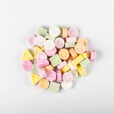 Tablet şekerler izole edildi. Sıkıştırılmış şeker tozu şekerlemesi, dekstroz şeker kolye parçaları, C vitamini tabletleri, beyaz arka planda pastiller.