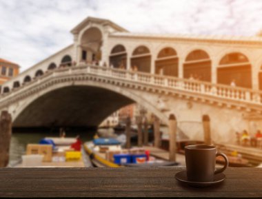 Bulanık turistik Venedik manzaralı koyu kahve fincanı. Küçük espresso fincanı, fotokopi alanı olan kahve, ahşap arka planda sıcak içecek ile koyu kahve fincanı.