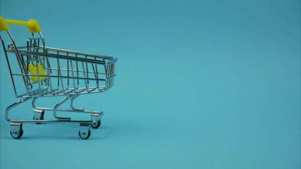 Shopping Trolley Books Moving Blue Background Stop Motion — Vídeo de Stock