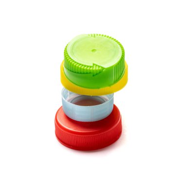 Plastik şişe kapağı kulesi izole edilmiş. Geri dönüşüm hdpe malzeme yığını, daire polietilen kapağı, beyaz arka planda renkli kapaklar
