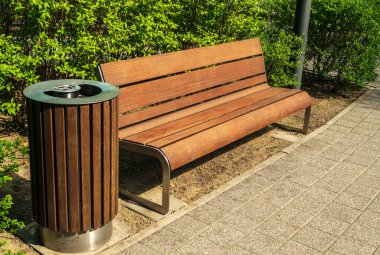 Wooden garbage bin and bench in park. Outdoor city architecture, wooden benches, outdoor chair, empty plank seat, comfortable bench in recreation area