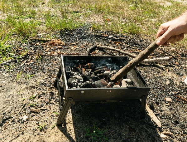 Small grill, portable barbecue, bbq with flame and smoke. Mini barbecue for outdoor recreation, tailgating, entertaining, beach parties