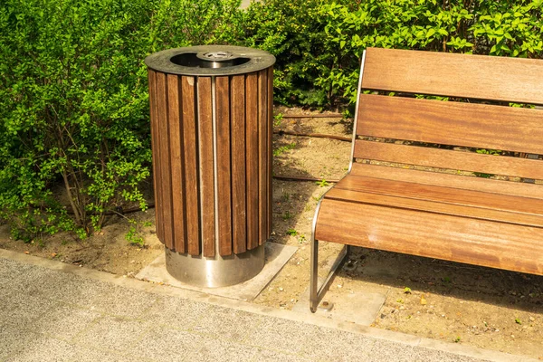 Wooden garbage bin, trash can and bench in park. Old wood waste bin for mixed trash and not recyclable waste