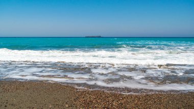 Sea waves on pebble beach texture background. Transparent ocean water, rocky shore pattern, summer mockup with copy space, stone shoreline, vacation concept
