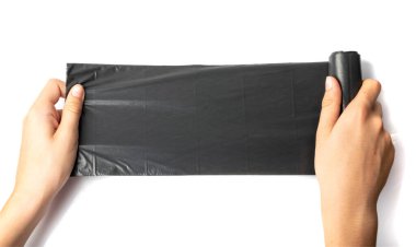 Hands holding garbage bag isolated. Trash package roll, new rolled plastic bin bags, black polyethylene waste container on white background