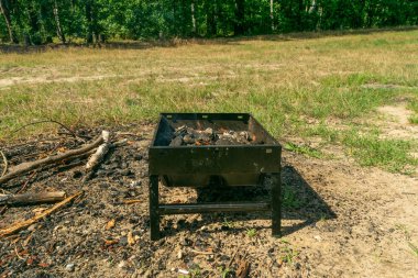 Small grill, portable barbecue, bbq with flame and smoke. Mini barbecue for outdoor recreation, tailgating, entertaining, beach parties