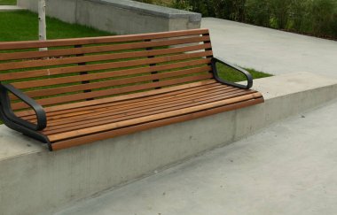 Parkın yeni modern bankı. Şehir mimarisi, ahşap banklar, açık sandalye, şehir mobilyası, boş tahta koltuk, dinlenme alanında rahat bank