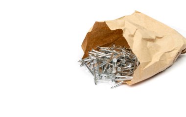 Metal nail pile in paper bag isolated. Steel nails, construction hardware on white background top view