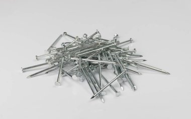 Metal çivi yığını izole edildi. Çelik çiviler, beyaz arkaplanda inşaat donanımı