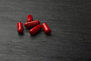 Siyah tabakta kırmızı haplar. Kapsül seti, ağrı kesici, ağrı kesici, yatıştırıcı hap koleksiyonu, ilaç kapsülleri