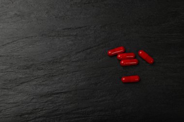 Siyah tabakta kırmızı haplar. Kapsül seti, ağrı kesici, ağrı kesici, yatıştırıcı hap koleksiyonu, ilaç kapsülleri