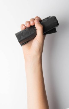 Hands holding garbage bag isolated. Trash package roll, new rolled plastic bin bags, black polyethylene waste container on white background