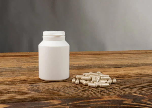 Bitkisel ilaç modeli. Ahşap arka planda ilaç şişesi, geleneksel ilaç kapsülleri, takviye, bitki kapsülü, bitkisel vitaminler, fotokopi alanı olan biyolojik destek şişesi.