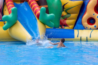 Çocuklar bilardo oynar ve yüzer. İki çocuk bilardoda eğleniyor. Arkadaşlar havuza su sıçratıyor, eğleniyorlar. Yaz tatili kavramı. Yüzme havuzunda oynayan sevimli çocuklar. 