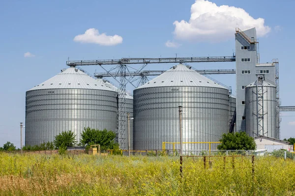 Agricultural Silos. Storage and drying. Storage of crop. Grain elevator. Metal grain elevator in agricultural zone. Agriculture storage for harvest. Grain silos. Exterior of agricultural factory.