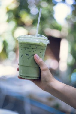 Bir fincan yeşil çay tutan kadın.