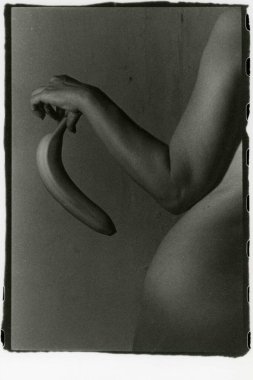 Çıplak bir kız elinde büyük bir muz tutuyor. Dikkat! Resim tahıl ve diğer analog fotoğraf eserlerini içeriyor.!