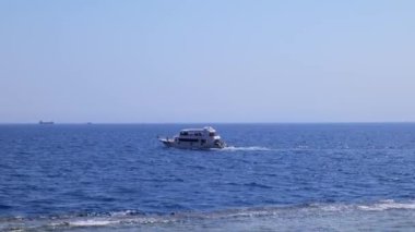 Açık denizlerde yelken açan turistli beyaz bir yat.