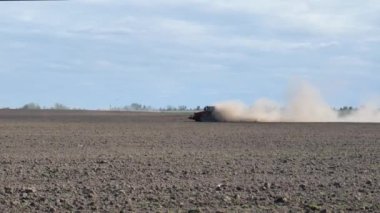 Traktör, toza dönüşmüş bir ocak direğiyle tarlayı sürüyor. sonbahar tarım işleri