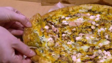 Pizza üstü manzaralı. Eller sıcak pizzanın parçalarını yavaş çekimde toplar.