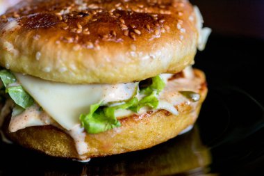 Arkaplanda iştah açıcı kabuklu hamburger..