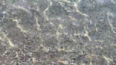 Kayalık sahilde yumuşak dalgalar sörf yapar