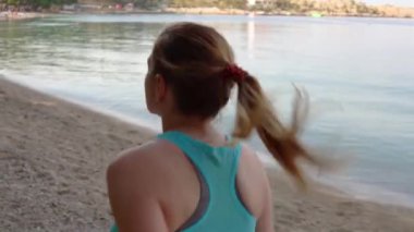 Genç kız kumsalda ağır çekim videoda koşuyor.