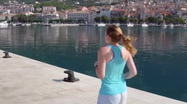 Genç kız kumsalda ağır çekim videoda koşuyor.